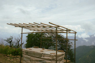 A handcrafted bamboo cabin veranda overlooking a misty mountain landscape in early morning light.