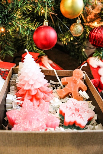 a box filled with christmas cookies next to a christmas tree