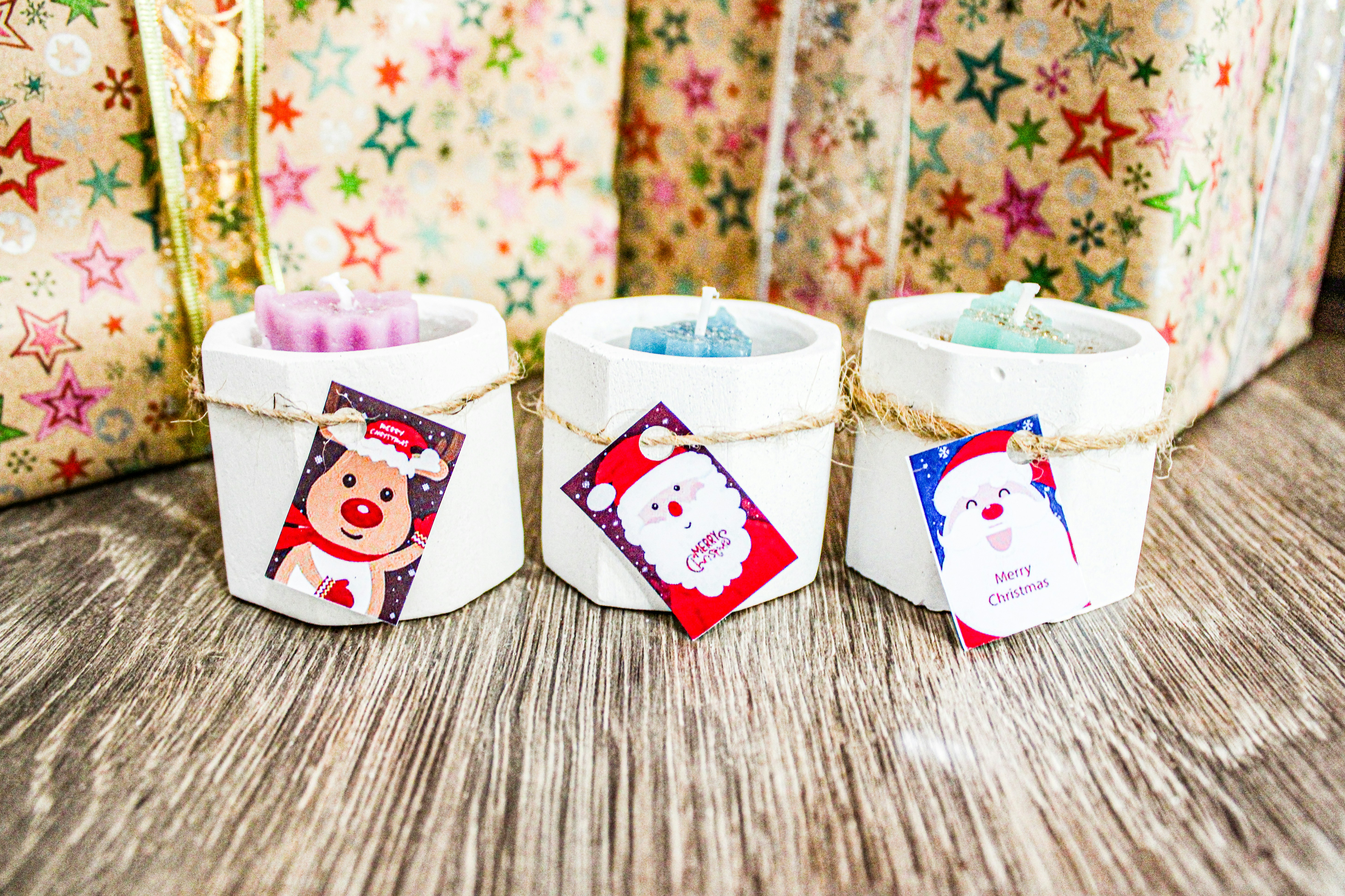 Three small candles wrapped in twine on a table photo Free North