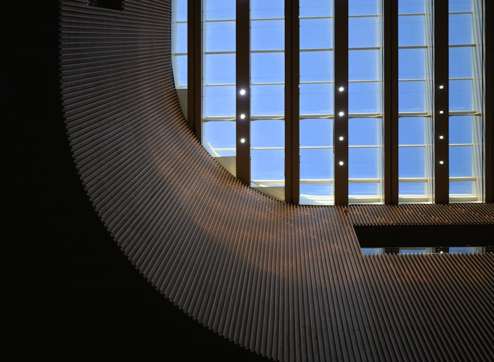 a curved metal wall with a clock on it