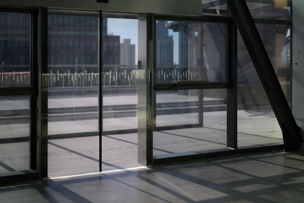 an empty room with glass doors and a view of a city