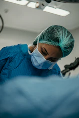 a surgeon wearing a surgical mask and scrubs his face