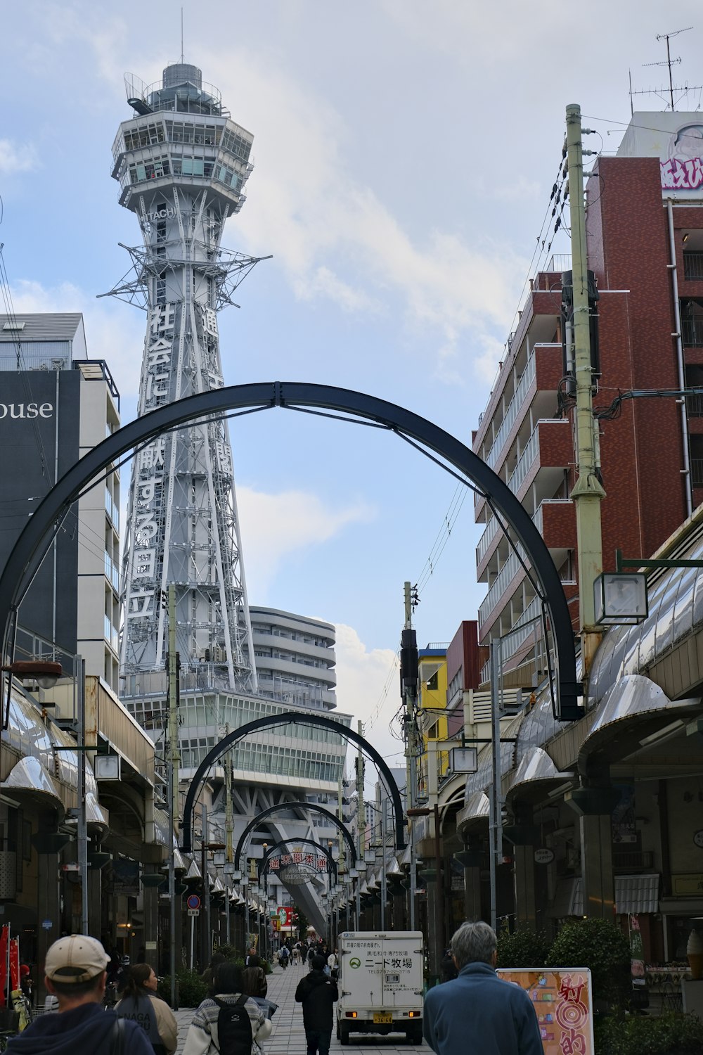 una calle de la ciudad con una torre alta al fondo