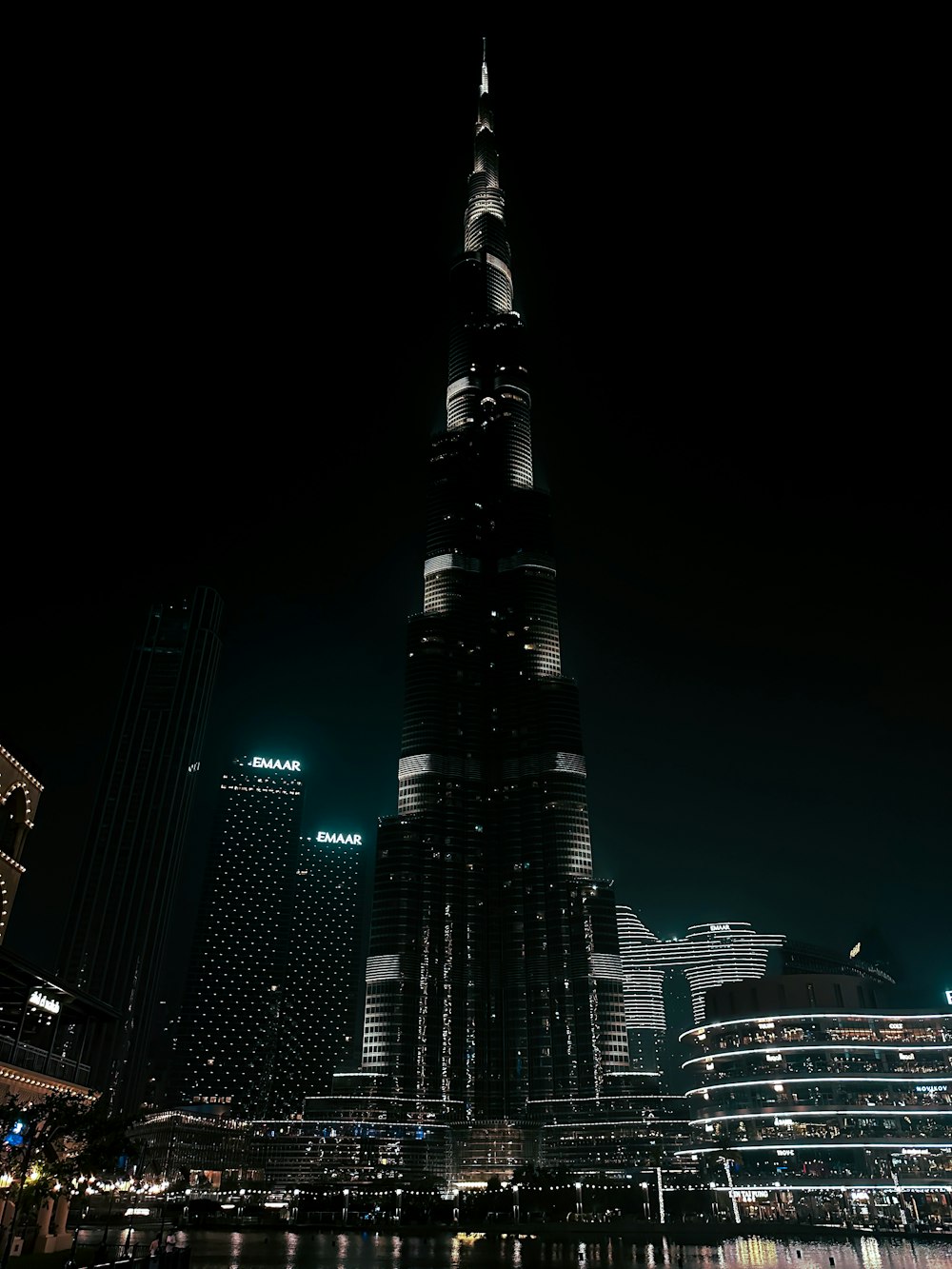 a night view of a very tall building in the middle of a city