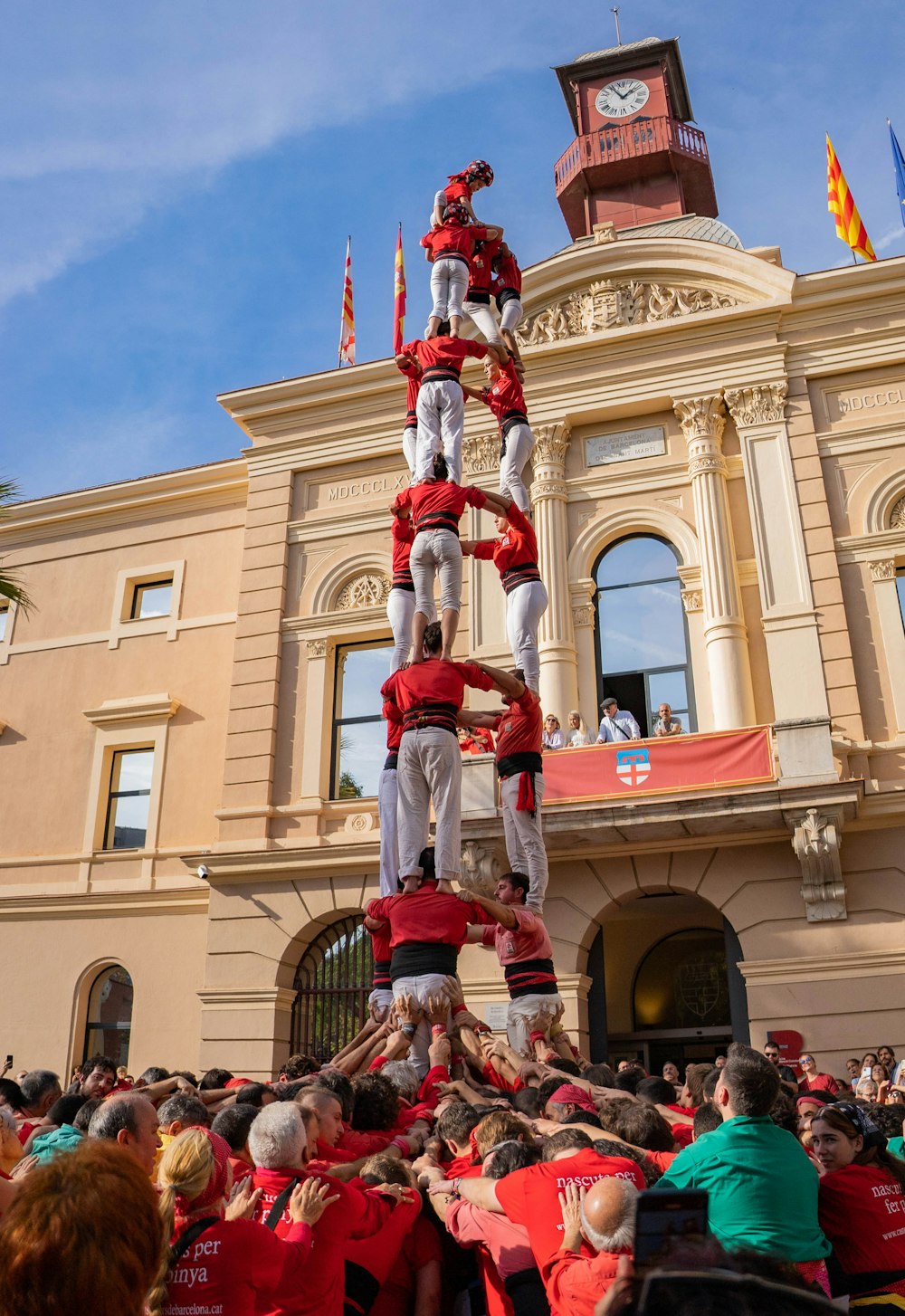 Un grupo de personas de pie en lo alto de un poste frente a un edificio