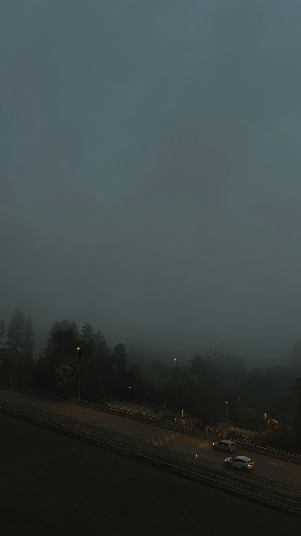 a foggy night with cars driving down the road