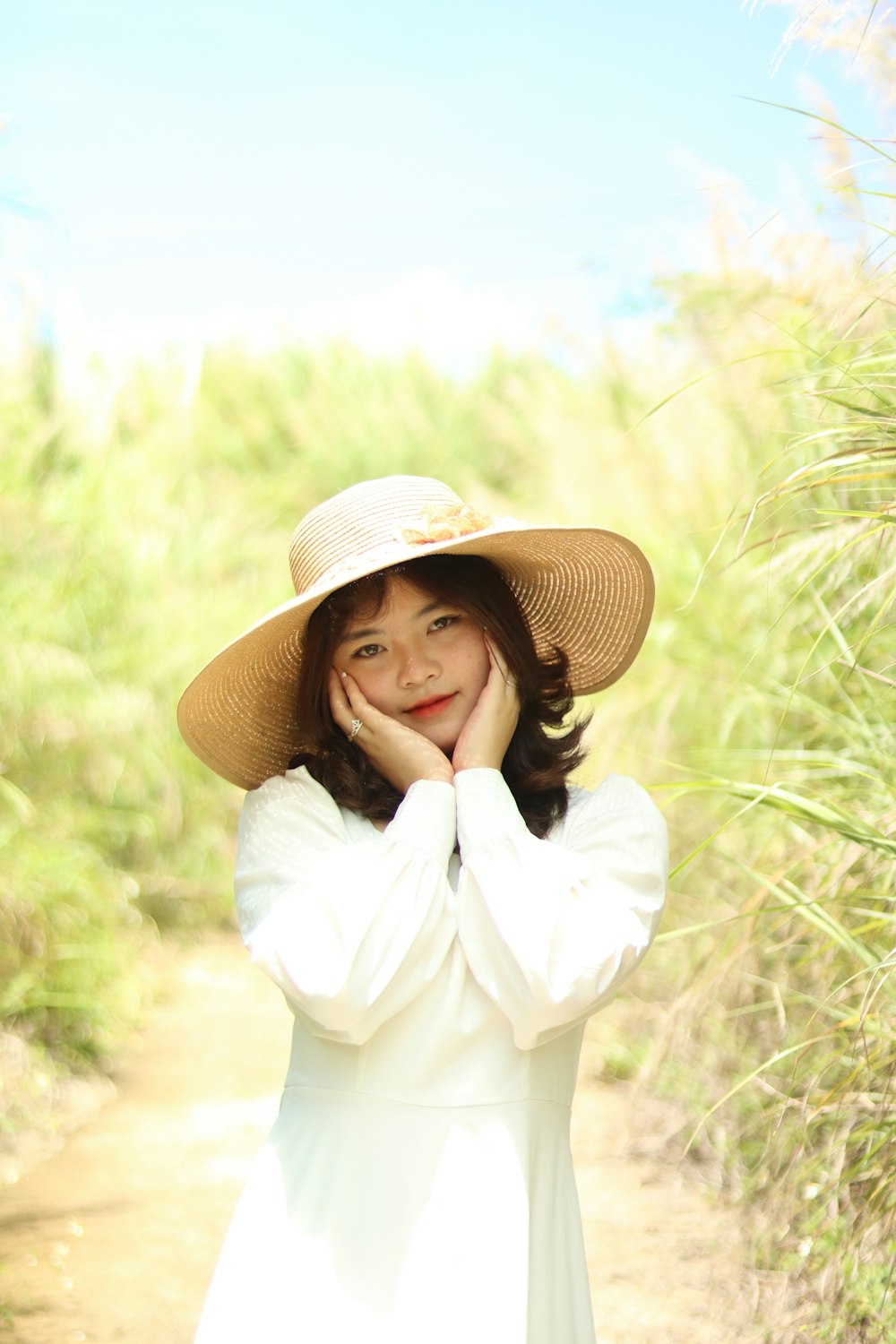 a woman in a white dress and hat posing for a picture