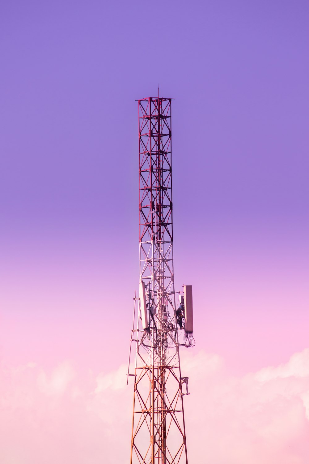 a cell phone tower with a purple sky in the background