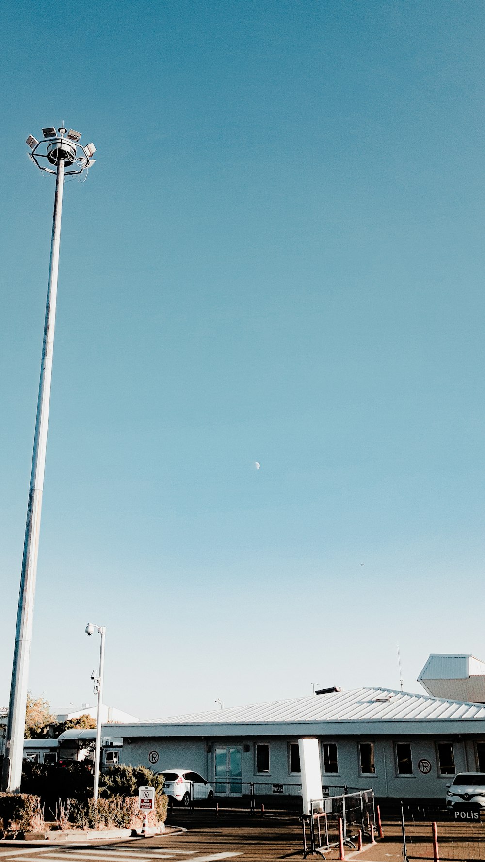 a tall light pole sitting in the middle of a parking lot