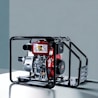 A portable diesel engine generator encased within a black metal frame, featuring a combination of silver, red, and black components. The engine housing displays branding and instructional graphics. The backdrop is a plain, muted gray-blue surface.