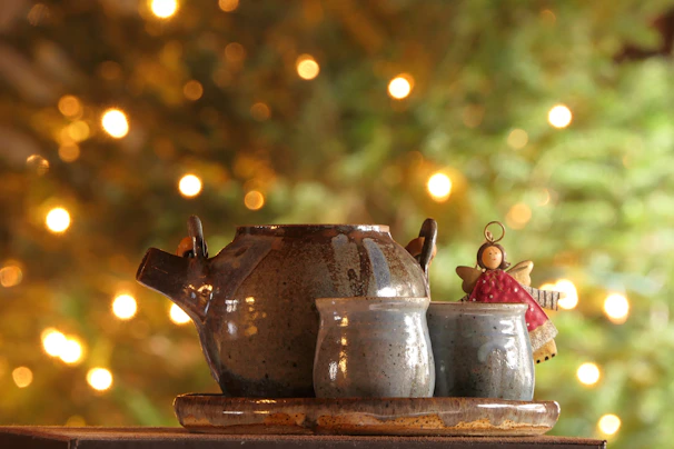 A cozy scene with a ceramic teapot and matching cups on a wooden table.