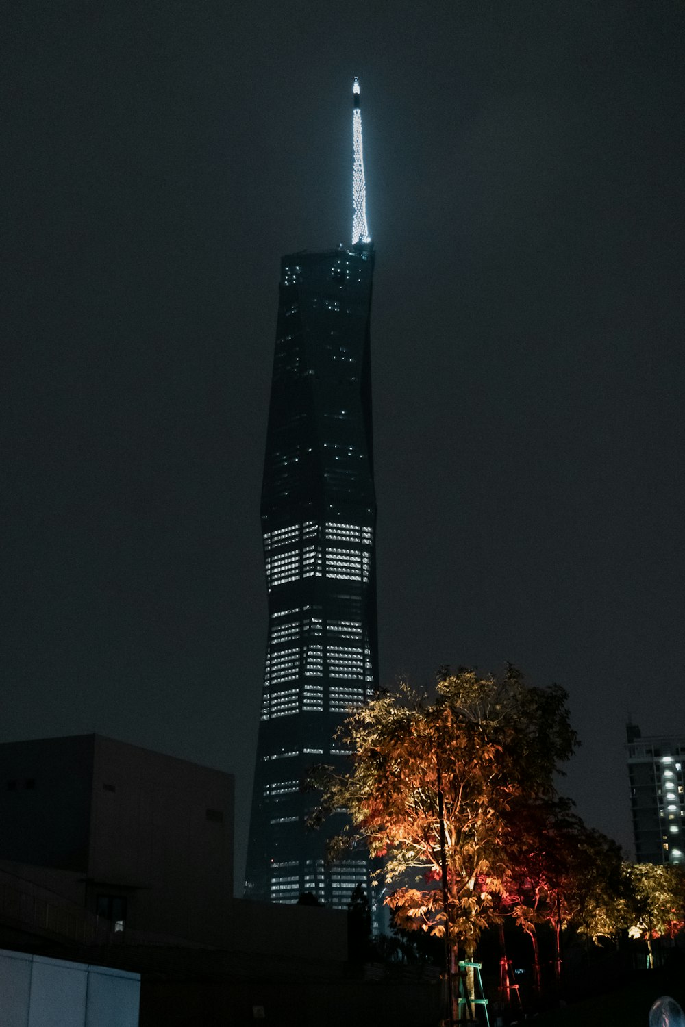 a tall building lit up at night in the city
