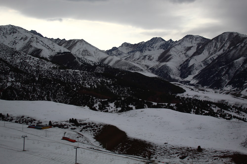 a snow covered mountain range with a ski lift in the foreground