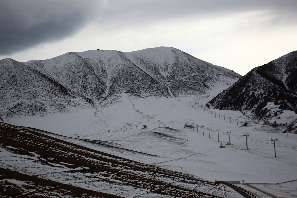 a snow covered mountain with a ski lift in the distance