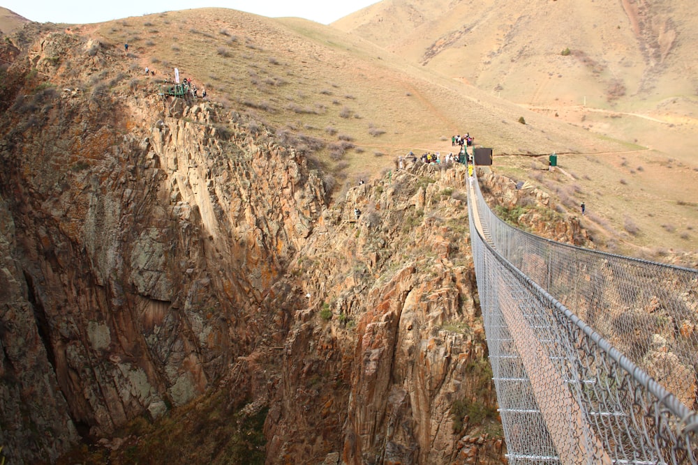 a group of people walking across a suspension bridge