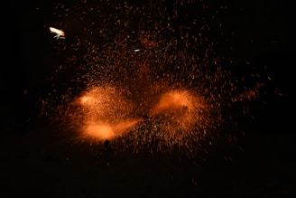 A close-up of a Van de Graaff generator sparking with raw electrical energy against a dark background.