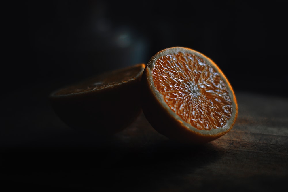 a half of an orange sitting on top of a wooden table