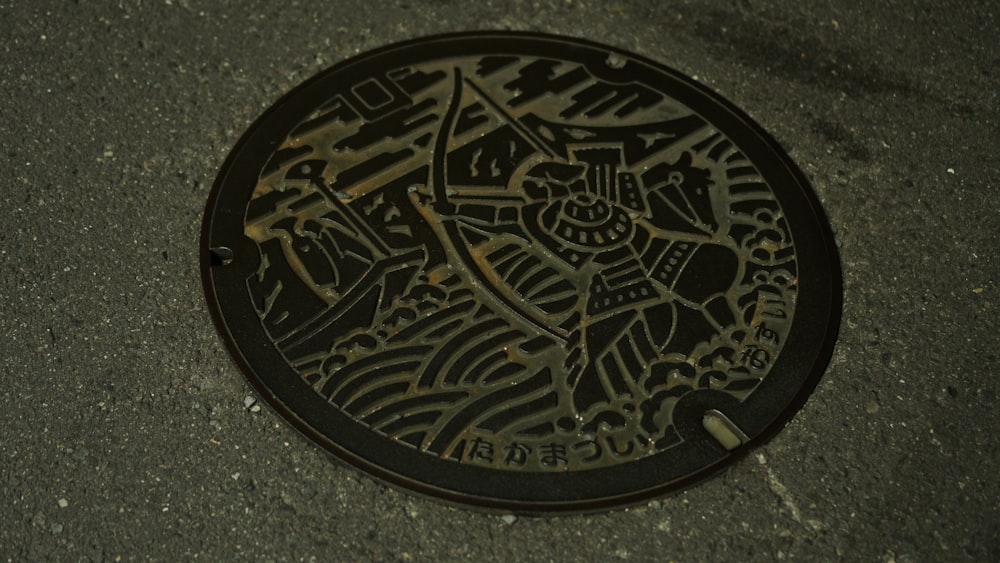 a manhole cover on the ground with a drawing on it