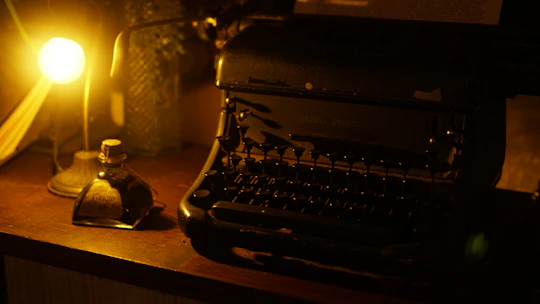 A writer’s desk with scattered screenplay pages and a vintage typewriter bathed in warm light.