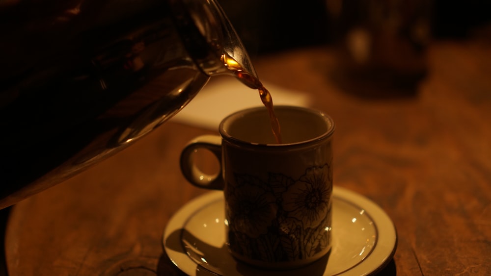 a cup of coffee being poured into a cup