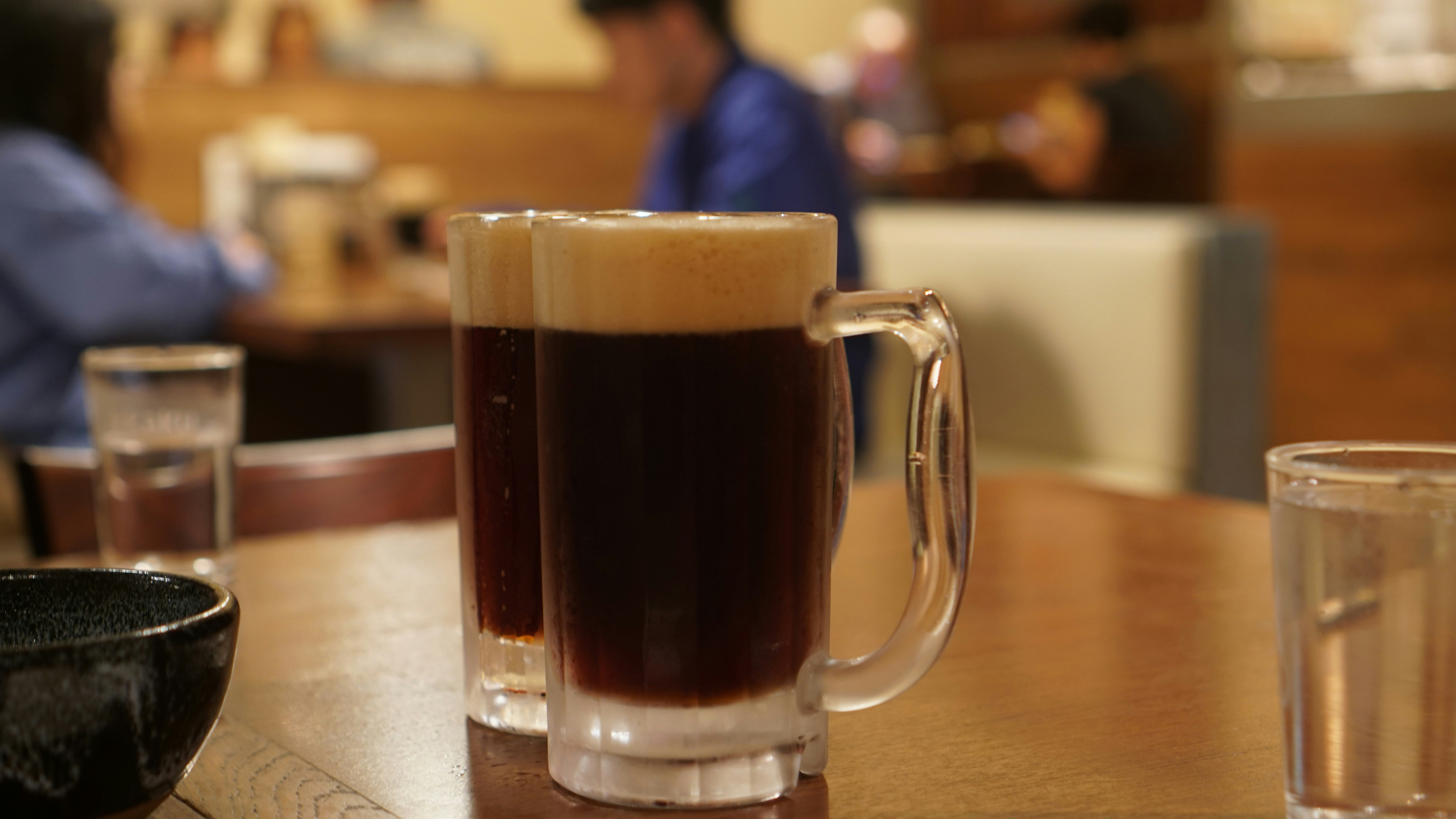 a cup of coffee sitting on top of a wooden table