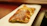 Close-up of golden, crispy tequeños arranged on a rustic wooden board.