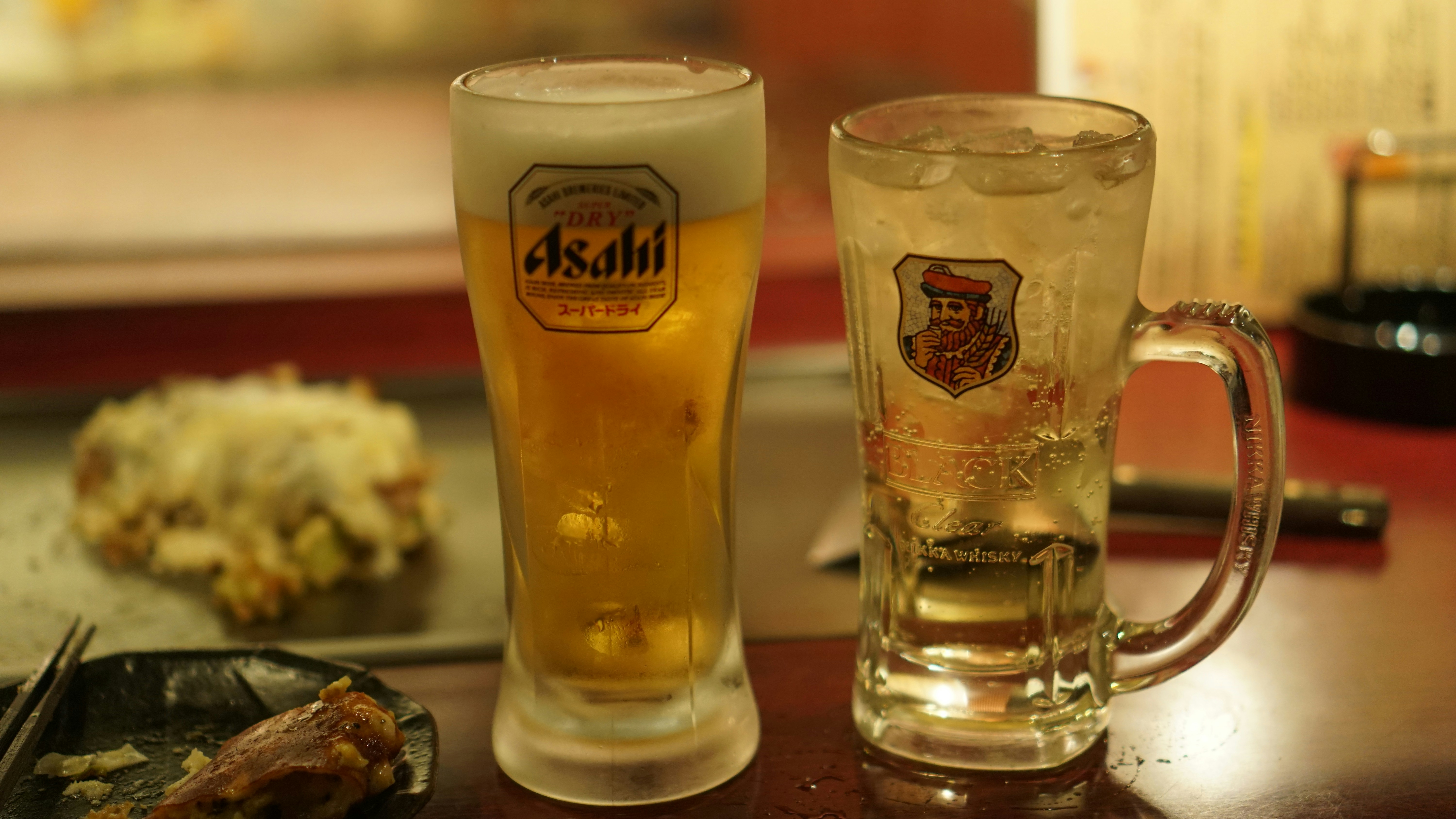 two glasses of beer sitting on a table