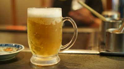 a glass of beer sitting on top of a table