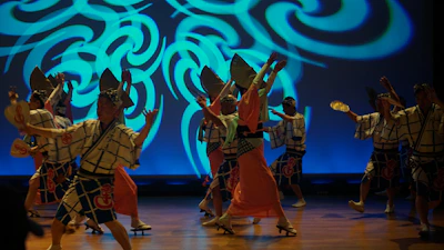 Shinwa Eisa performers in bright costumes mid-dance, capturing the spirit of Okinawan culture.