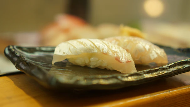 Overhead view of a sushi platter illuminated by soft neon cyan lighting.