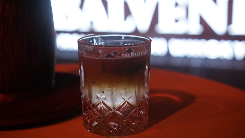 a glass of liquid sitting on top of a table