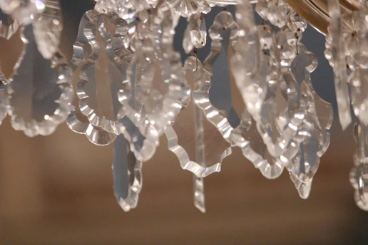 Close-up of a handmade beaded suncatcher sparkling in sunlight against a window.