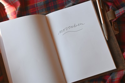 an open book with a pen on top of it