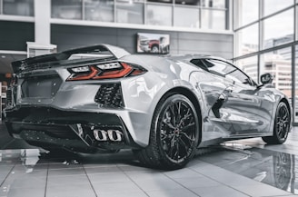 A sleek car image with a polished, reflective floor in a showroom.