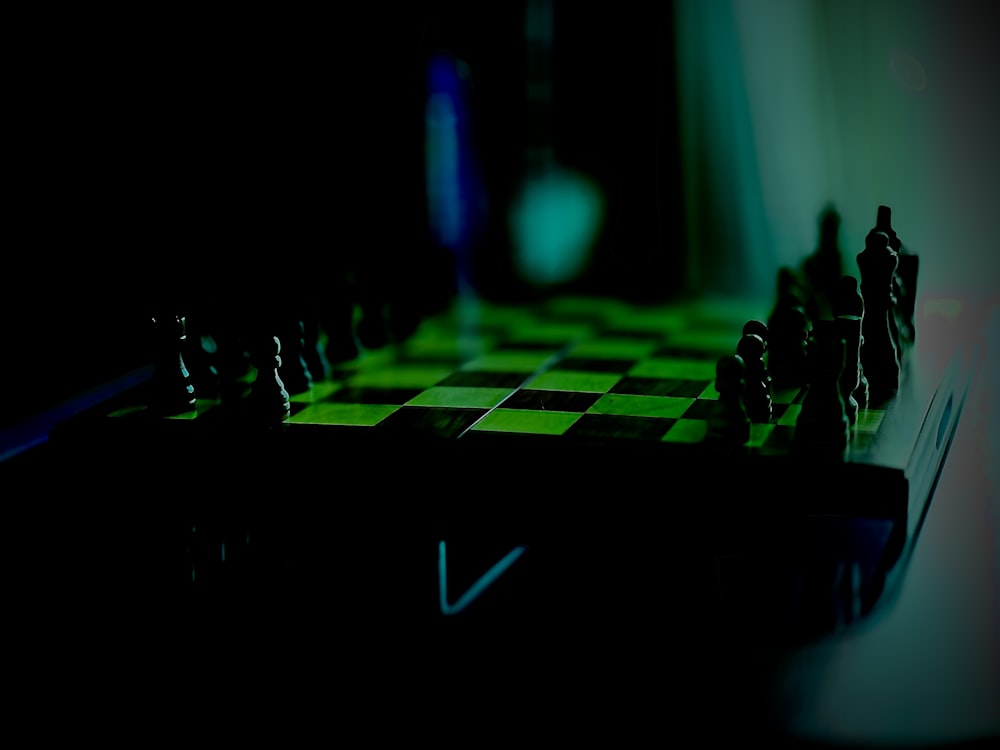 a black and green chess board with chess pieces on it