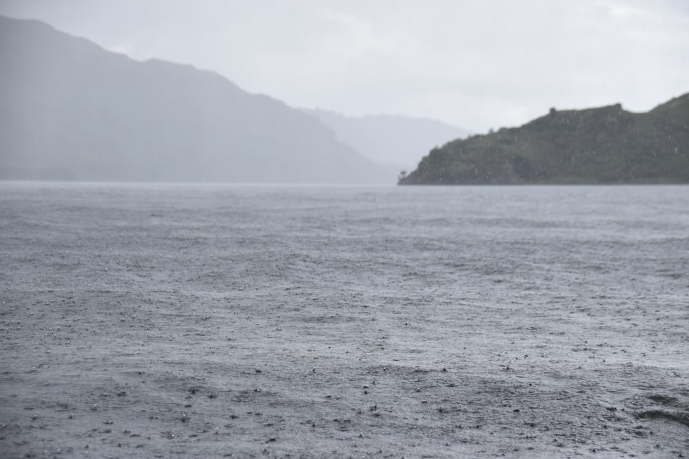 a body of water with a hill in the background