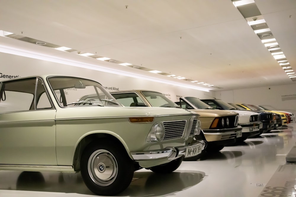 Una fila de coches viejos en una sala de exposición