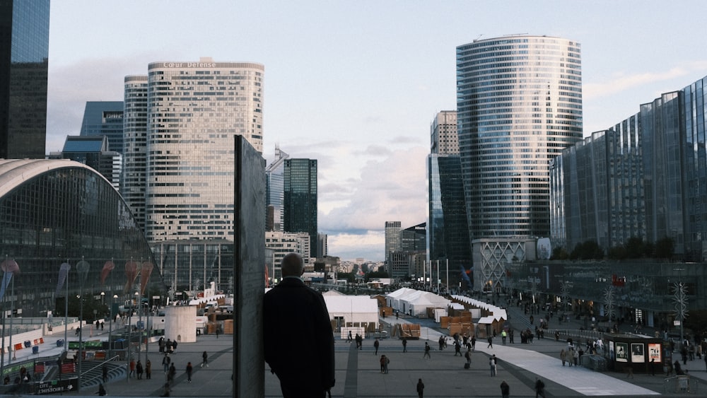 a man standing in front of a bunch of tall buildings