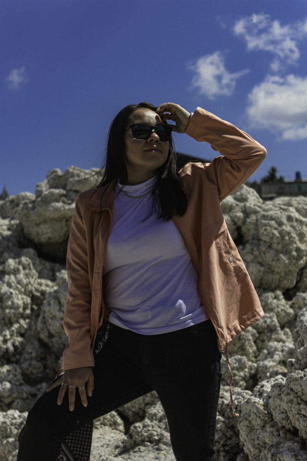 a woman standing in front of some rocks