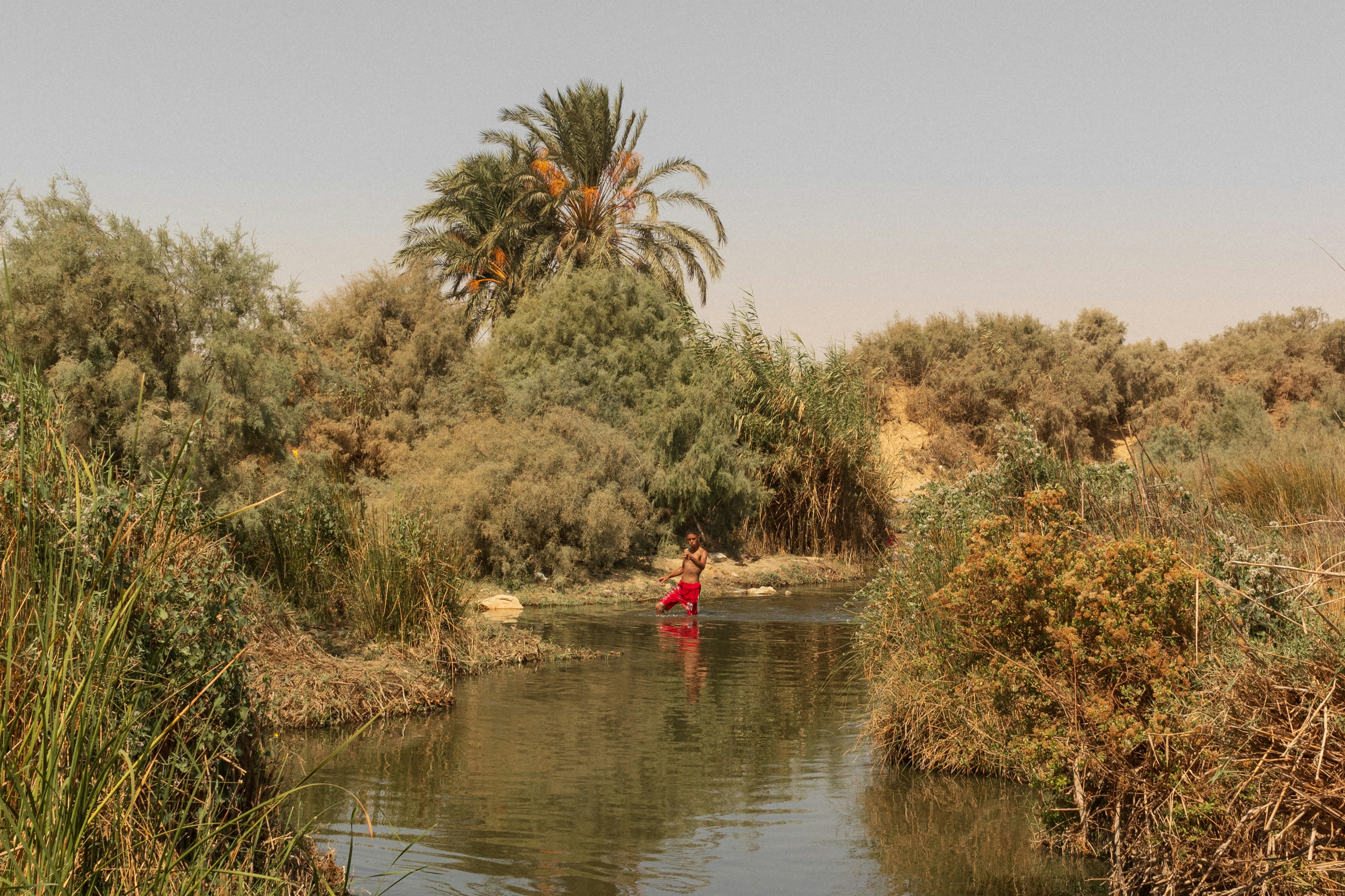 A man in a red shirt is in a body of water