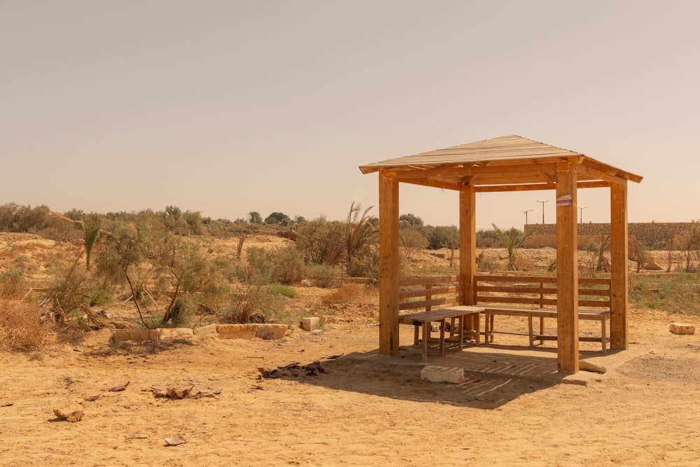 a wooden shelter in the middle of a desert