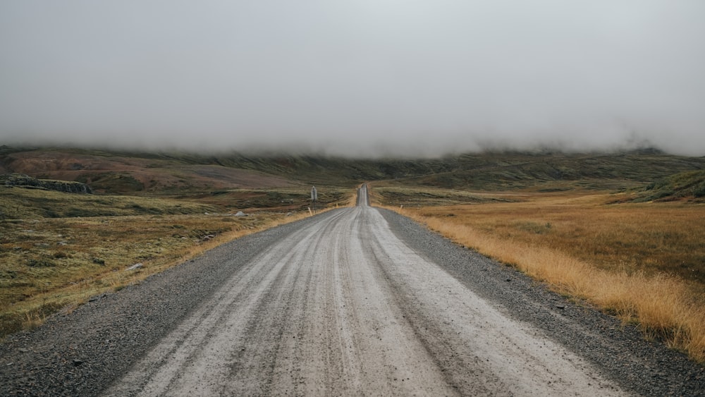 a gravel road in the middle of a field