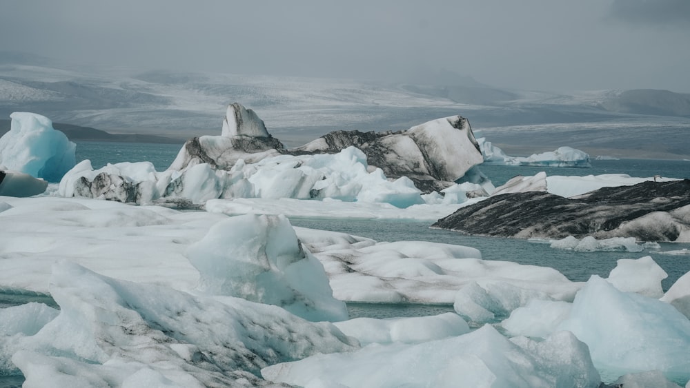 a group of icebergs floating on top of a body of water