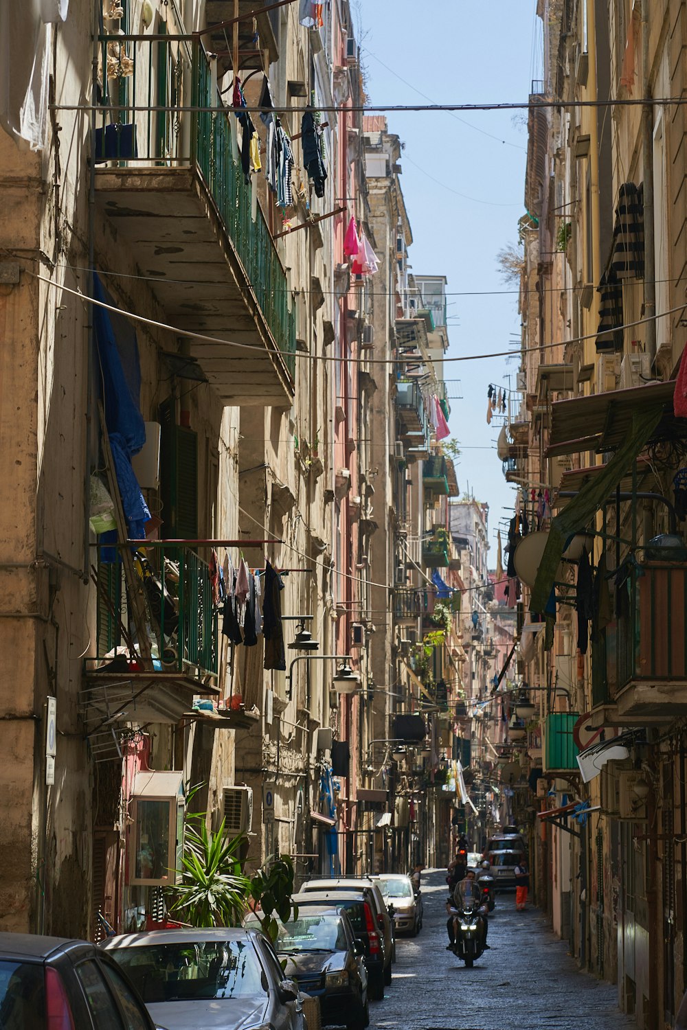 a narrow city street with cars parked on both sides