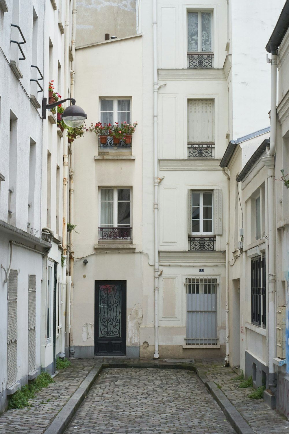 a cobblestone street lined with tall white buildings