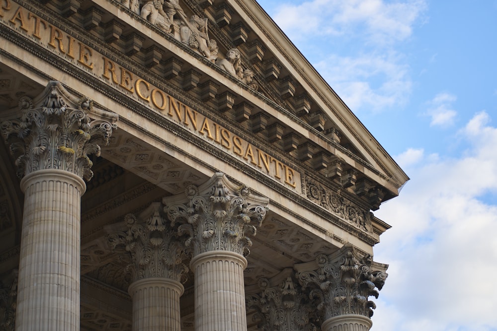 a close up of a building with columns and a sky background