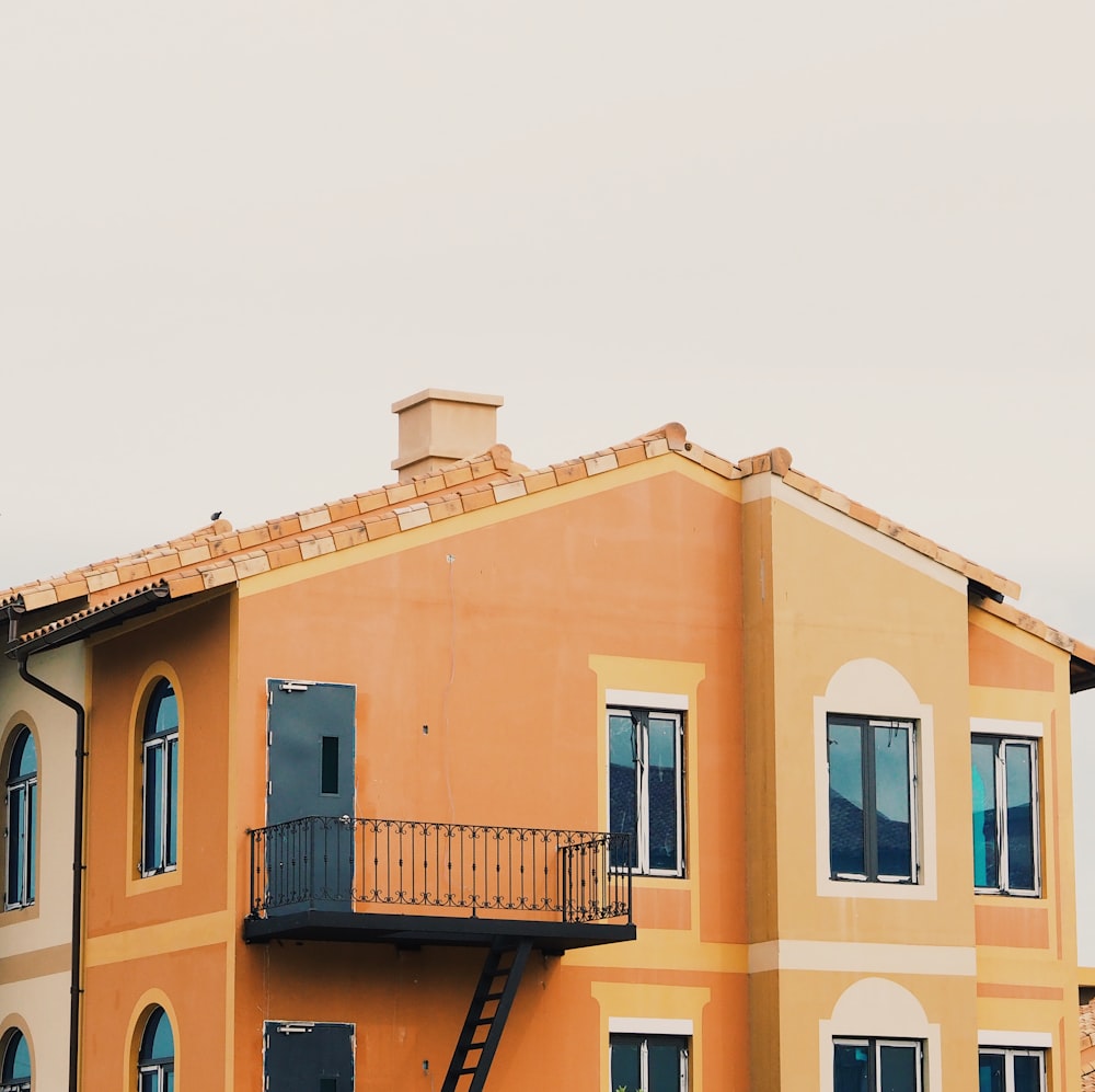 a tall yellow building with a balcony and balconies