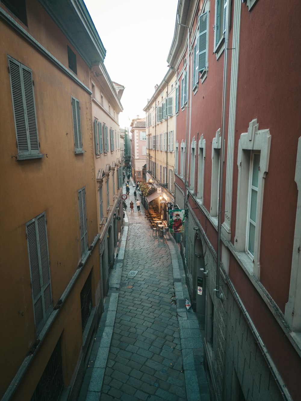 a narrow street with people walking down it