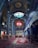 A richly decorated interior featuring intricate geometric patterns and colorful tile work on the walls and ceiling. A grand chandelier hangs prominently, with ornate rugs covering the floor. The ambience is serene, with a combination of blue, yellow, and red tones dominating the space.