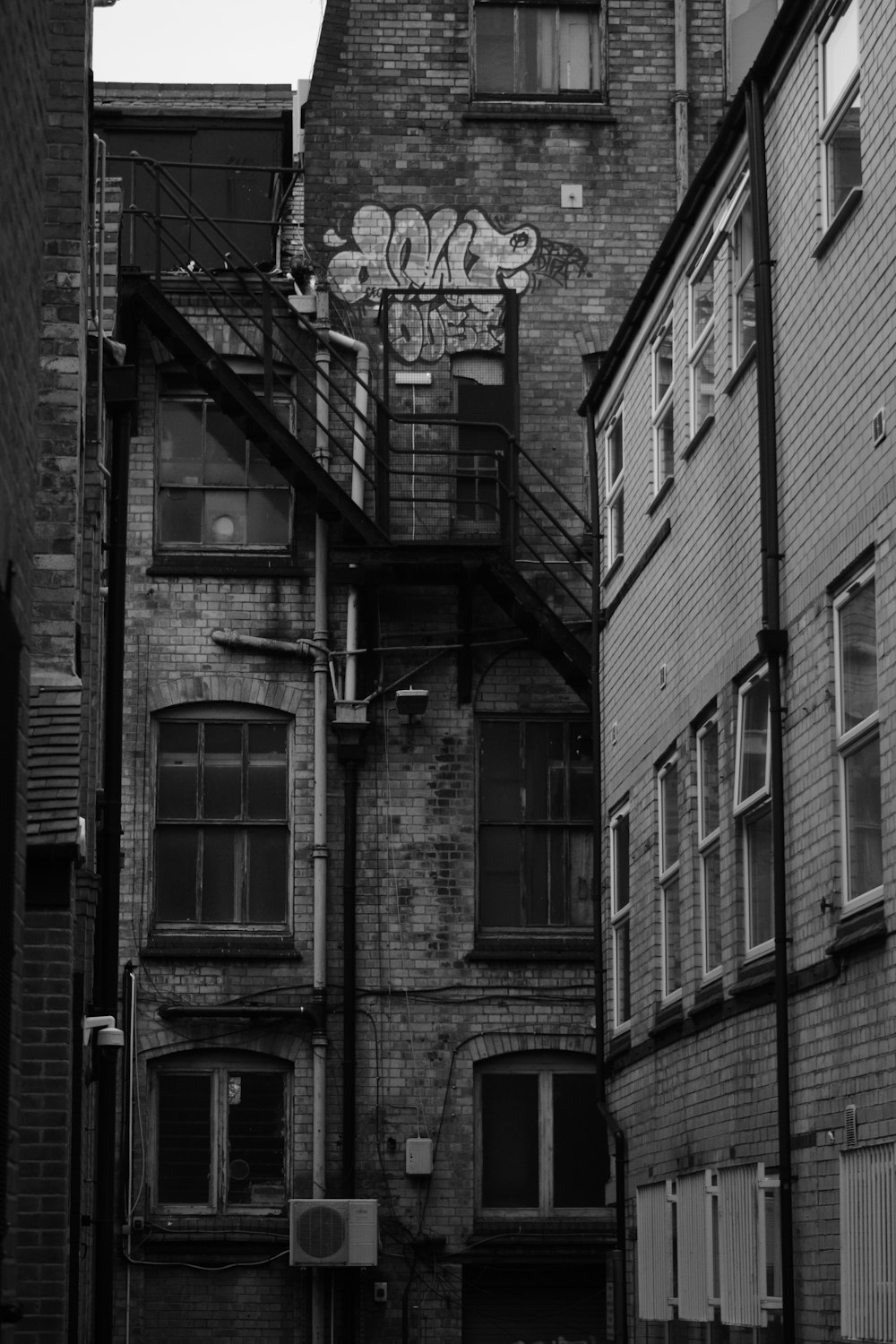 a black and white photo of a building with graffiti on it